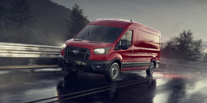 a red ford transit on the road