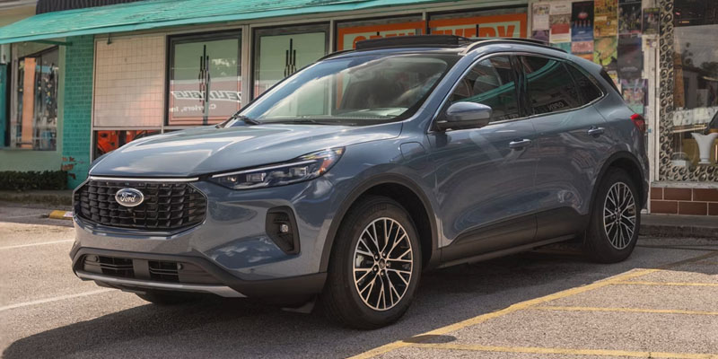 Gray Ford Escape parked on a city street outside a storefront
