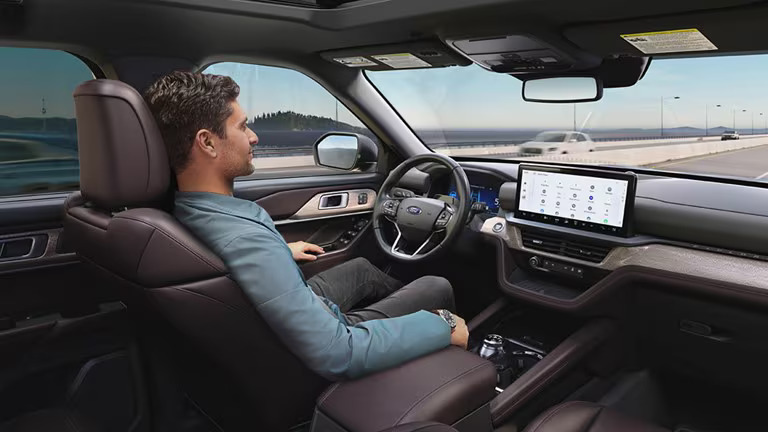 Driver using the Ford vehicle interior touchscreen and dashboard while on the road