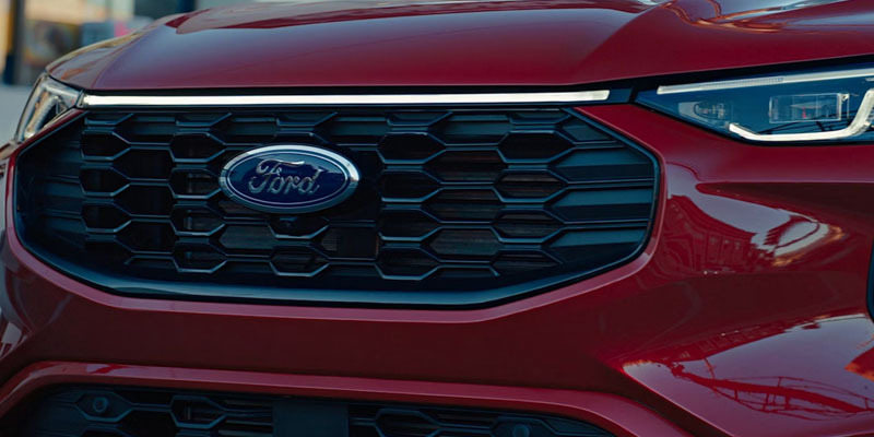 Close-up view of a red Ford vehicle grille and front design details