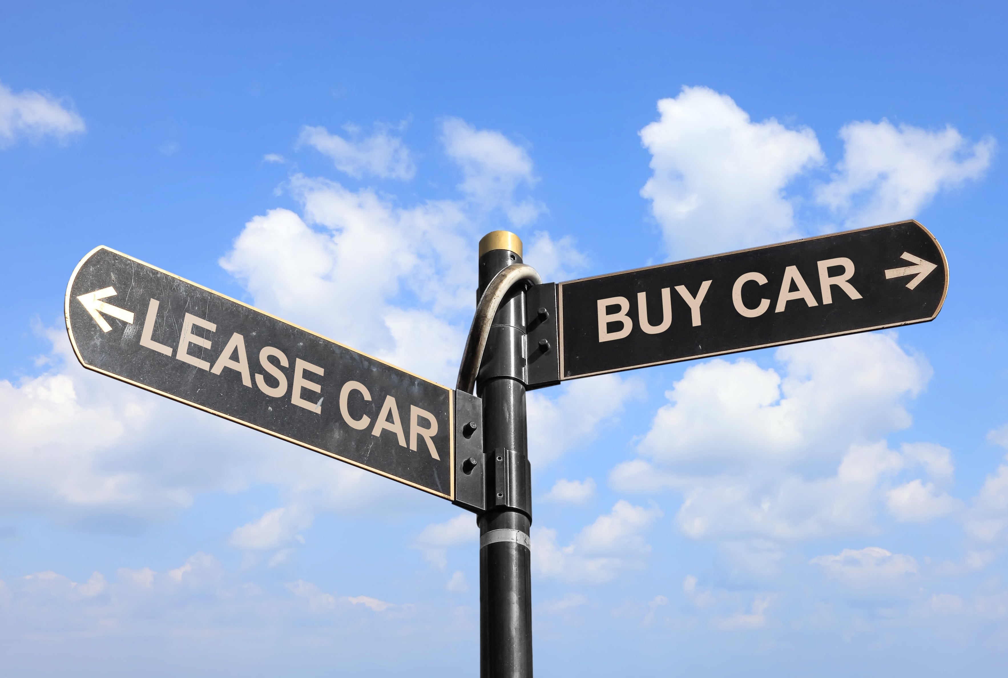 Road sign with "Buy Car" and "Lease Car" directions against a blue sky with clouds.